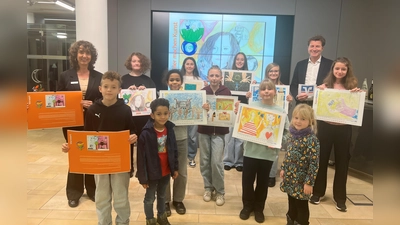 Stolz präsentieren die Kinder und Jugendlichen den Kalender 2026 „Schüler machen Kunst“ zusammen mit Bankvorstand Klaus Berger (r.) und Marketingreferentin Michaela Steiner (l.). (Foto: VR Bank Dachau)