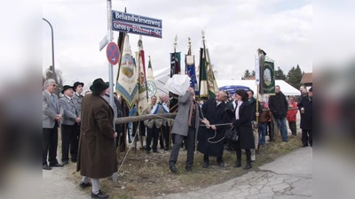 Mit einem energischen Ruck haben hier gerade Stadtrat Josef Schmid als Vertreter des Oberbürgermeisters, Helmut Pfundstein, Vorsitzender des Freiflächenvereins, und Sylvia Hartl (von links), Großnichte der Festwiesen-Stifter, das neue Straßenschild von seiner Umhüllung befreit. (Foto: Eva Schraft)
