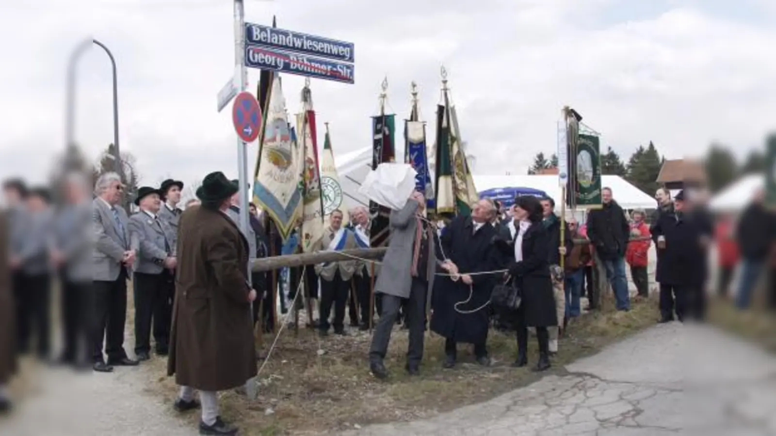 Mit einem energischen Ruck haben hier gerade Stadtrat Josef Schmid als Vertreter des Oberbürgermeisters, Helmut Pfundstein, Vorsitzender des Freiflächenvereins, und Sylvia Hartl (von links), Großnichte der Festwiesen-Stifter, das neue Straßenschild von seiner Umhüllung befreit. (Foto: Eva Schraft)