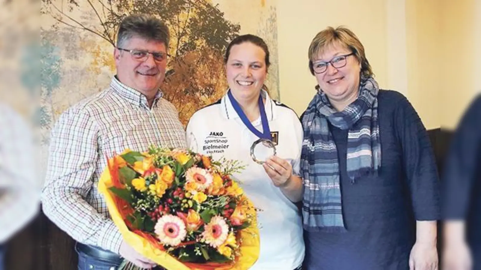 Mit einem Blumenstrauß wurde die frischgebackene Vizeweltmeisterin Franziska Dücker (Mitte) von den Vorständen Sepp Troidl und Michaela Reitmeyer begrüßt. 	 (Foto: Verein)