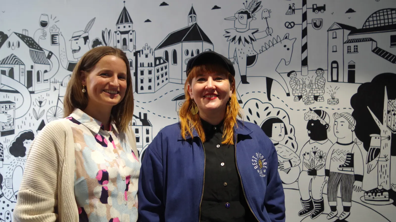 Künstlerin Miriam Frank (rechts im Bild) und Magdalena Waller, Geschäftsführerin von Kultur im Trafo, freuen sich über das gerade fertiggestellte Wandbild im Eingangsbereich des Hauses. (Foto: kö)