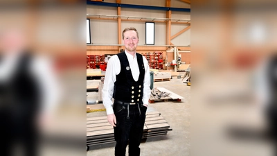Der stellvertretende Innungsobermeister Benedikt Lachner in der traditionellen Zimmerer-Kluft in der Produktionshalle seines Betriebs. (Foto: Riffert/JOB 2026)