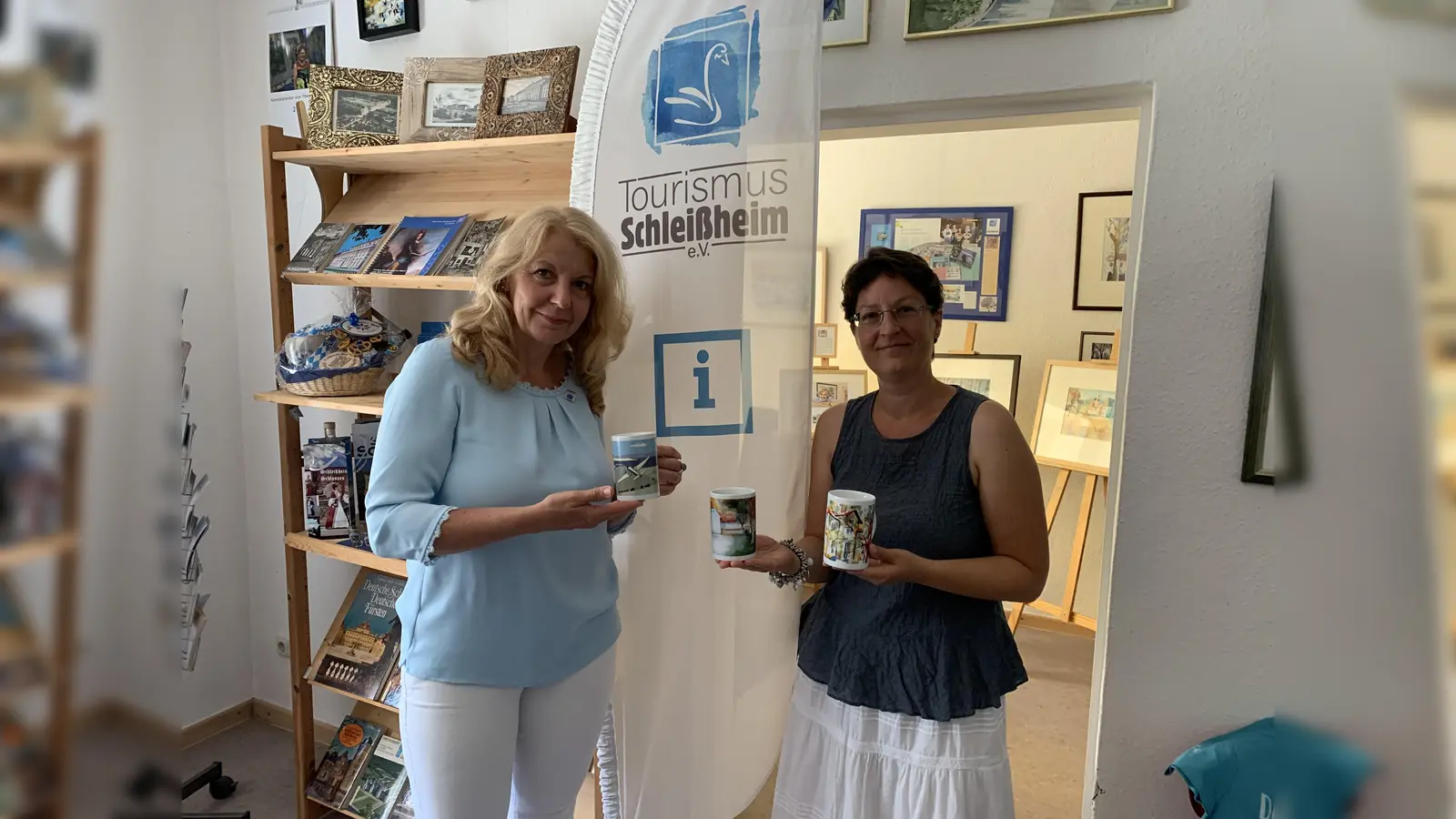 Ingrid Lindbüchl (l.) und Isabelle Herbst präsentieren die Künstlertassen der Jahre 2016 bis heute. (Foto: Daniel Mielcarek)