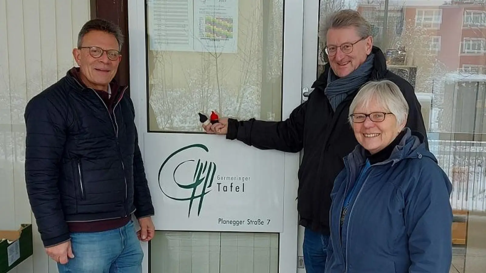 Reinhard Wilhelm (hinten rechts) und Wolfgang Winter (links) zeigen stolz die kleinen Wichtel, die Ingeborg Keil gebastelt hat. Die ehemalige Stadträtin unterstützt die Germeringer Tafel seit vielen Jahren. (Foto: Sozialdienst Germering)