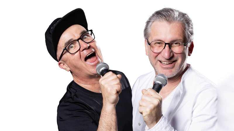 Uli Wurschy (l.) und Volker Becker stehen am 21. Oktober in der Halle E im Gasteig HP8 auf der Bühne und moderieren das Rudelsingen. (Foto: Joachim Pantel)