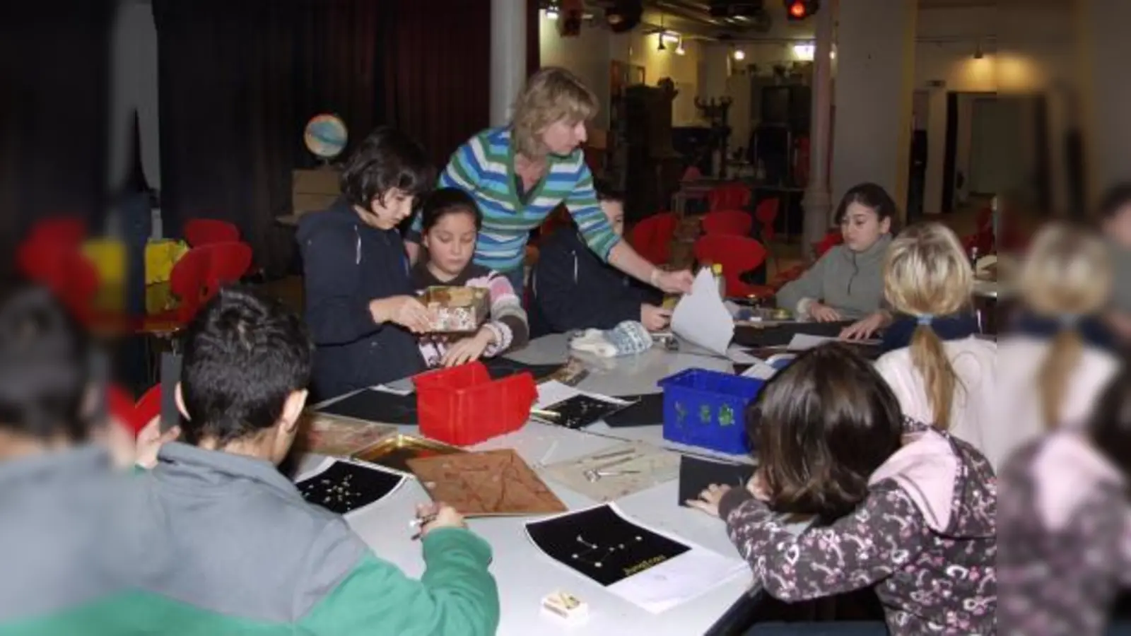 Konzentriert fertigen Schüler unter der Anleitung von Sozial- und Kulturpädagogin Conny Beckstein Fensterschablonen von allen Sternzeichen an – passend zum Thema „Erde, Planeten, Sonnensystem, Weltall“, um das sich drei Vormittage lang das spielerische Lernen drehte. (Foto: Eva Schraft)