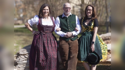 Mitarbeiterinnen und ein Mitarbeiter der aktion hoffnung präsentieren Trachtenoutfits, die beim Markt angeboten werden. (Foto:  Marie Kracker, aktion hoffnung)