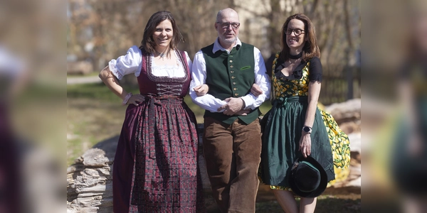 Mitarbeiterinnen und ein Mitarbeiter der aktion hoffnung präsentieren Trachtenoutfits, die beim Markt angeboten werden. (Foto:  Marie Kracker, aktion hoffnung)