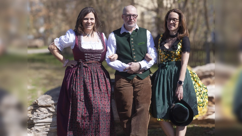 Mitarbeiterinnen und ein Mitarbeiter der aktion hoffnung präsentieren Trachtenoutfits, die beim Markt angeboten werden. (Foto:  Marie Kracker, aktion hoffnung)