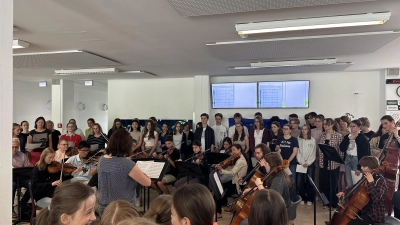 Chor und Orchester unter der Leitung von Martina Höller (vorne mittig im Bild) sorgten beim Europatag für einen festlichen Rahmen im Schulhaus. (Foto: Max-Born-Gymnasium)