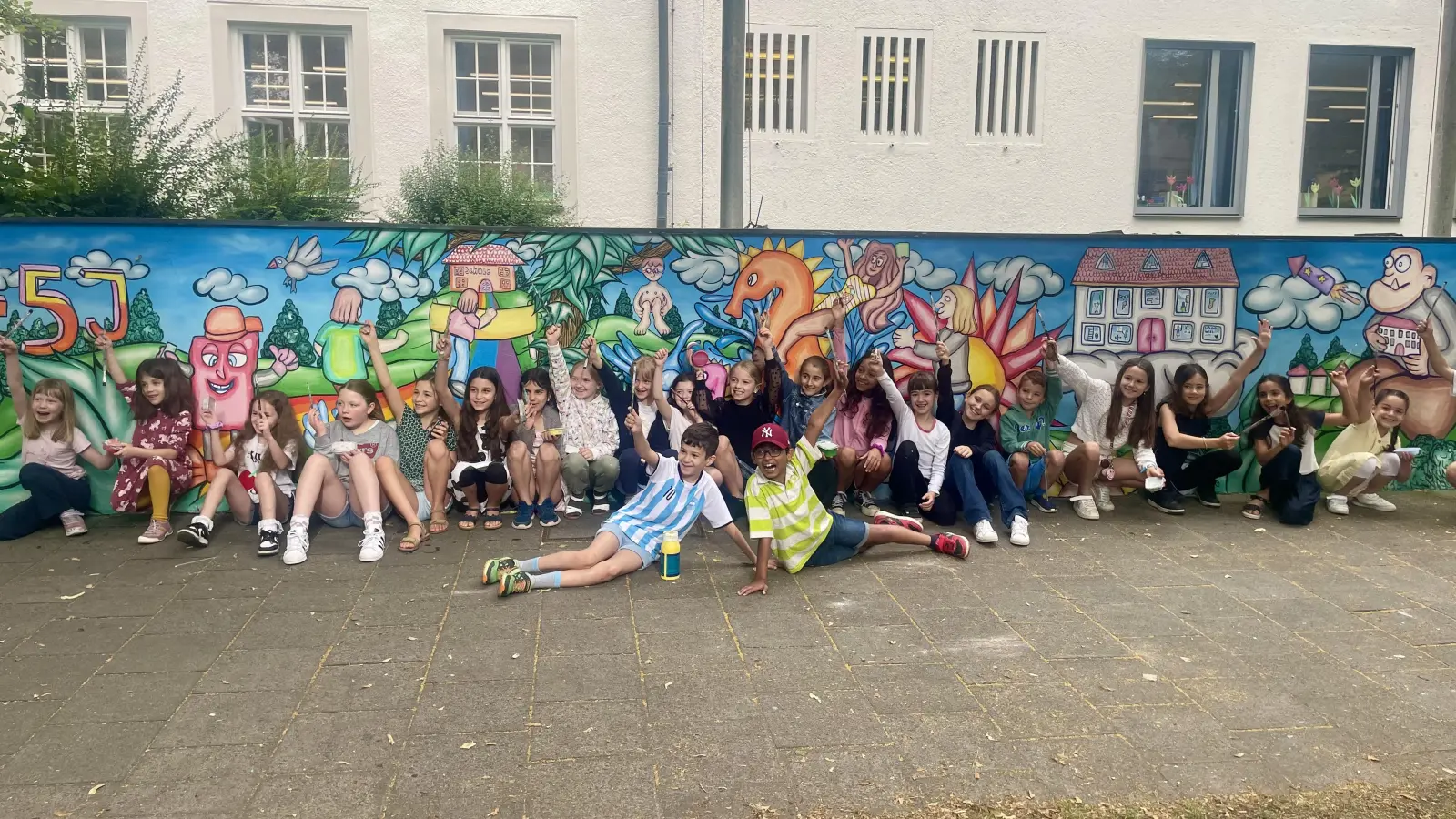 Stolz präsentierten die Kinder ihre neu gestaltete Mauer an der Grundschule. (Foto: Gliesche)