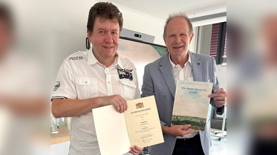 Für seinen langjährigen Einsatz als Feldgeschworener wurde Peter Engl (l.) vom Leiter der Kommunalreferats, Edwin Grodeke, mit einer Urkunde geehrt.  (Foto: © Kommunalreferat)