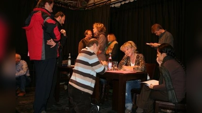 Dicht umringt im „Interim”: die Ansprechpartner des Kulturreferats für die Laimer Stadtteilwoche. Sogar knieend füllte einer, der mitmachen will, seine Anmeldung aus. (Foto: tg)