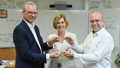 Martin Janke, Geschäftsführer der SWM Bildungsstiftung (links), übergibt die Auszeichnung an Schulleiterin Almut Wahl und Christian Koufou, den Vorsitzenden des Fördervereins der Mittelschule an der Feldbergstraße. (Foto: SWM/Robert Haas)