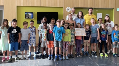 Knapp 5.200 Euro spendet die „Schrobi“ an den guten Zweck. Erwachsene im Bild von links: Lena Bühling (Lehrerin) Frank Bernhardt (Vorsitzender des Schul-Elternbeirats), Lens Stephan (WOHN:SINN e.V.) und Daniel Gromotka (Vorsitzender des Schul-Fördervereins).  (Foto: GS / Eva Ernst)