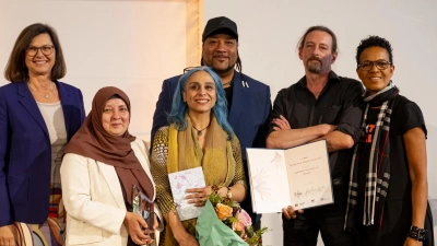 Bei der Verleihung des Bayerischen Integrationspreises: (v.l.) Ilse Aigner, Präsidentin des Bayerischen Landtags, Mo Asumang (r.) und den Preisträgern des Projekts „KulturBunt Neuperlach e.V.“, Bahar Auer, Kandala Nzanzala, Marc Haas und Hasene Onur. (Foto: Lennart Preiss)