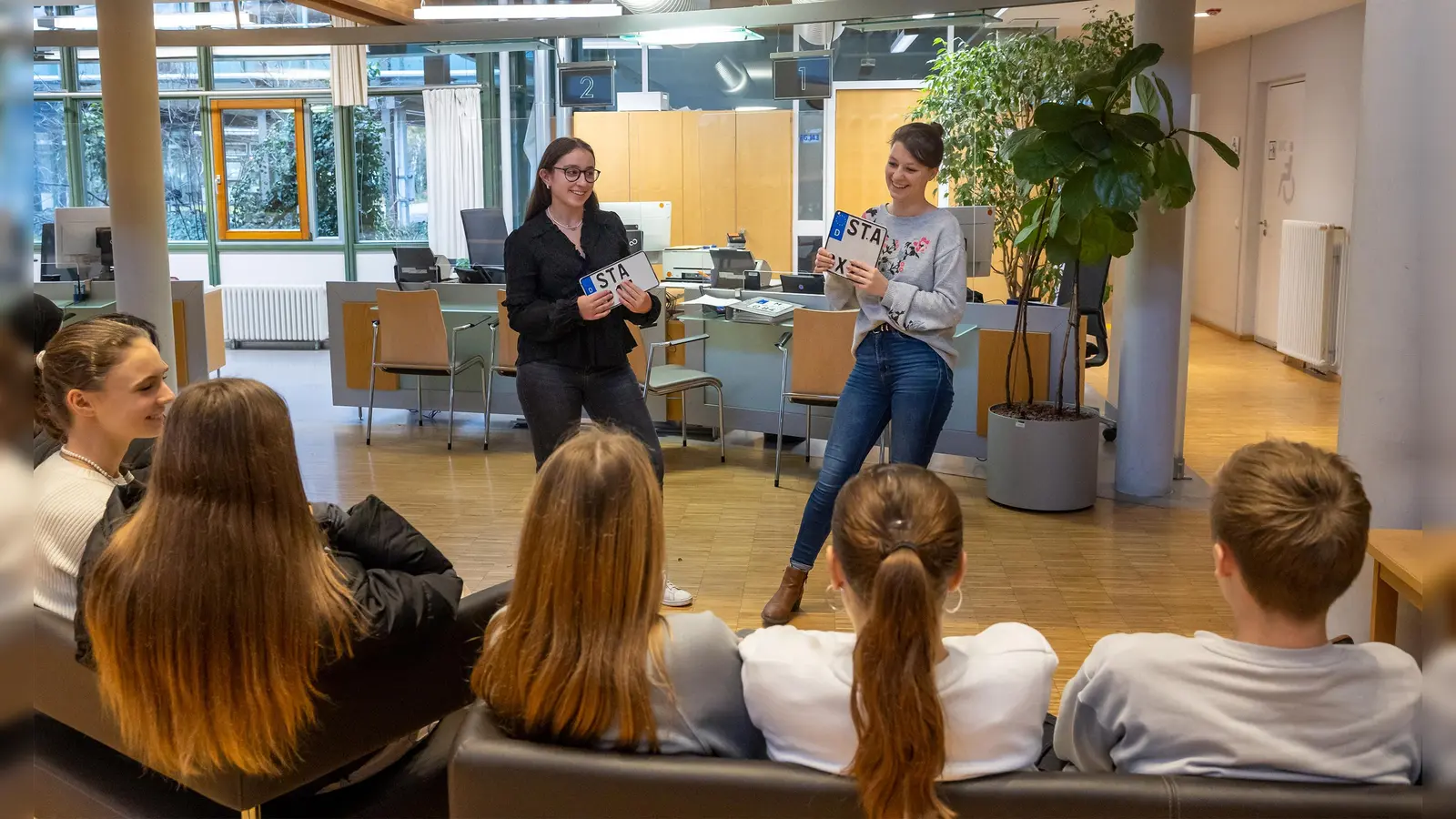 Die Mitarbeiter des Landratsamts Starnberg Annika Riedl (r.) und Auszubildende Magdalena Schmidberger erklärten den Schülerinnen und Schülern die Abläufe in der Zulassungsstelle. (Foto: LRA Starnberg)