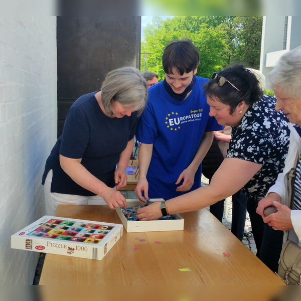 Pfarrgemeinderatsvorsitzende Dr. Andrea Hermann (1. v. l.) und Bücherei-Ehrenamtlicher Jakob Sunderer (2. v l.) legen die ersten Puzzleteile und eröffnen damit die neue Puzzle-Aktion in der Bücherei St. Martin in Germering. (Foto: St. Martin)