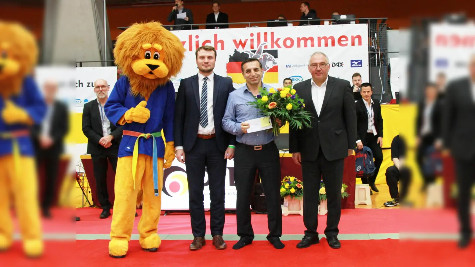 Yusuf Güngörmüs (2. v. r.) mit DJB-Präsident Peter Frese (rechts) und seinem Nachfolger Daniel Keller; daneben das Maskottchen des WJV. (Foto: Peter Franz)
