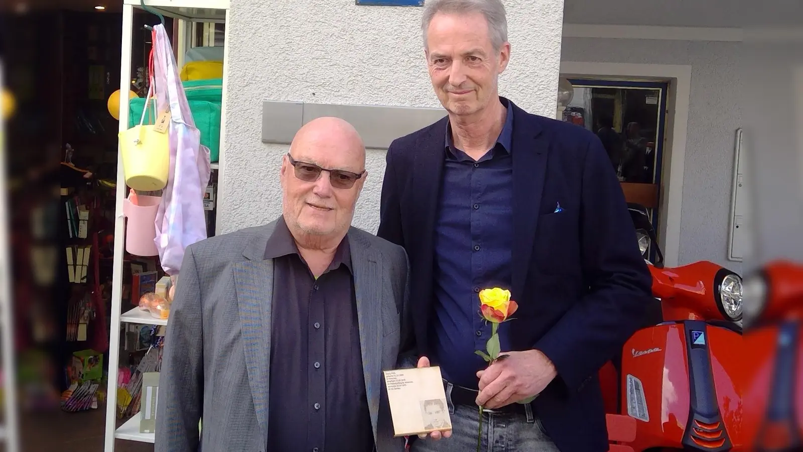 Familienmitglied Paul Maria Wittmann (links) und Initiator Thomas Hennet mit dem Erinnerungszeichen für Georg Pöltl, das nun in der Ismaninger Straße 77 hängt. (Foto: bas)
