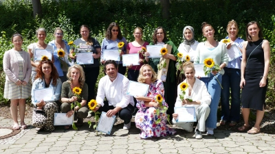 Stolze Dozentinnen Janine Beier-Seifert (ganz links) und Sandra Timm (ganz rechts) mit Teilnehmenden der Qualifizierung zur Pädagogischen Fachkraft, 13 hatten bestanden. (Foto: BRK Starnberg)