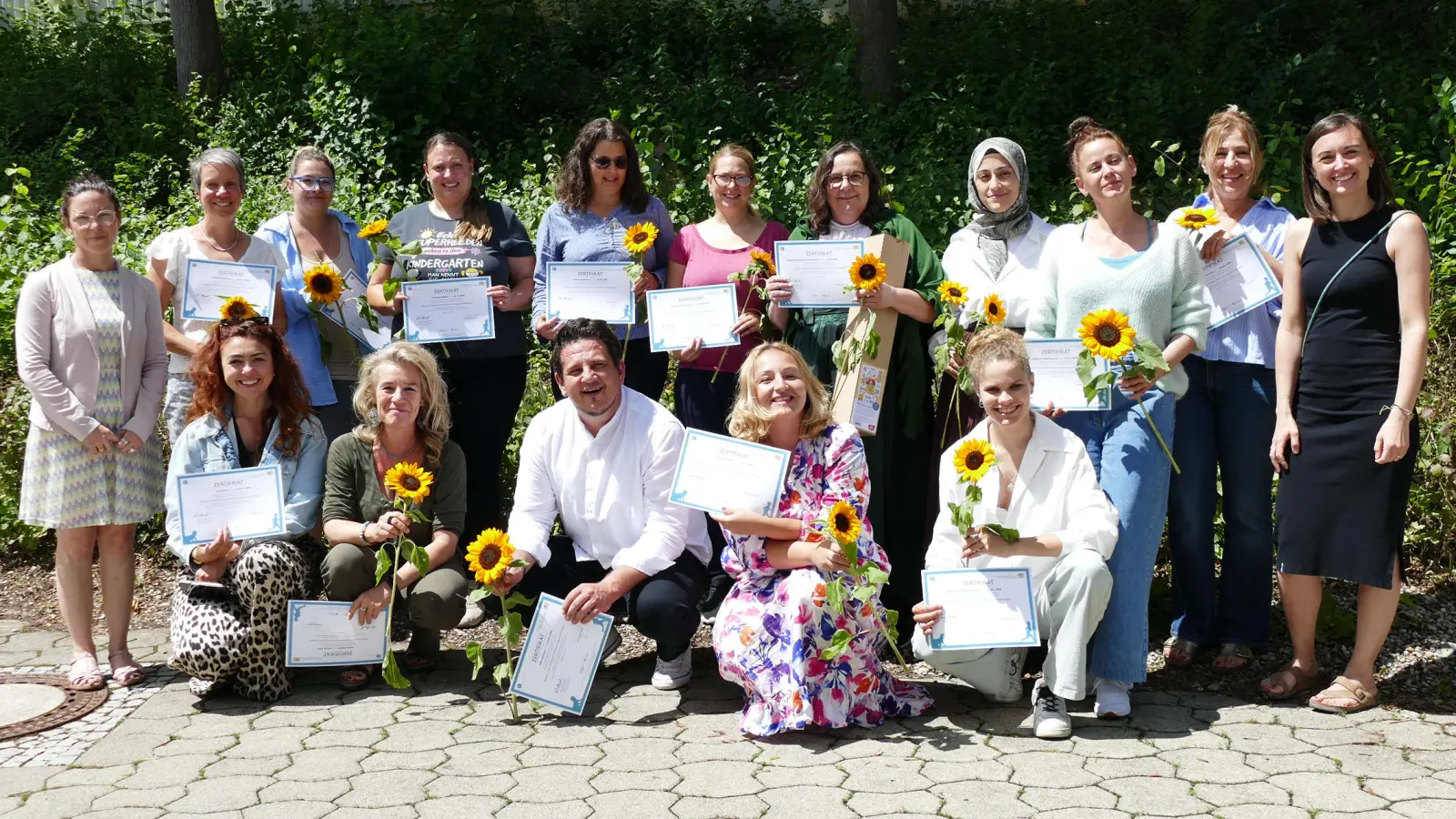 Stolze Dozentinnen Janine Beier-Seifert (ganz links) und Sandra Timm (ganz rechts) mit Teilnehmenden der Qualifizierung zur Pädagogischen Fachkraft, 13 hatten bestanden. (Foto: BRK Starnberg)
