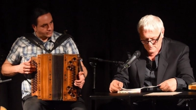 Josef Brustmann liest aus seinem Werk „Jeder ist wer”. Begleitet wird er von Martin Regnat am Akkordeon. (Foto: Olivia Reinecke)