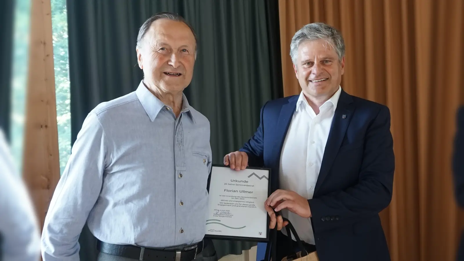 Bürgermeister Stefan Joachimsthaler (rechts) übergab die Urkunde für 20 Jahre ehrenamtliches Engagement zum Wohle der älteren Mitbürger an Seniorenbeiratsmitglied Florian Ullmer. (Foto: Gemeinde Alling)