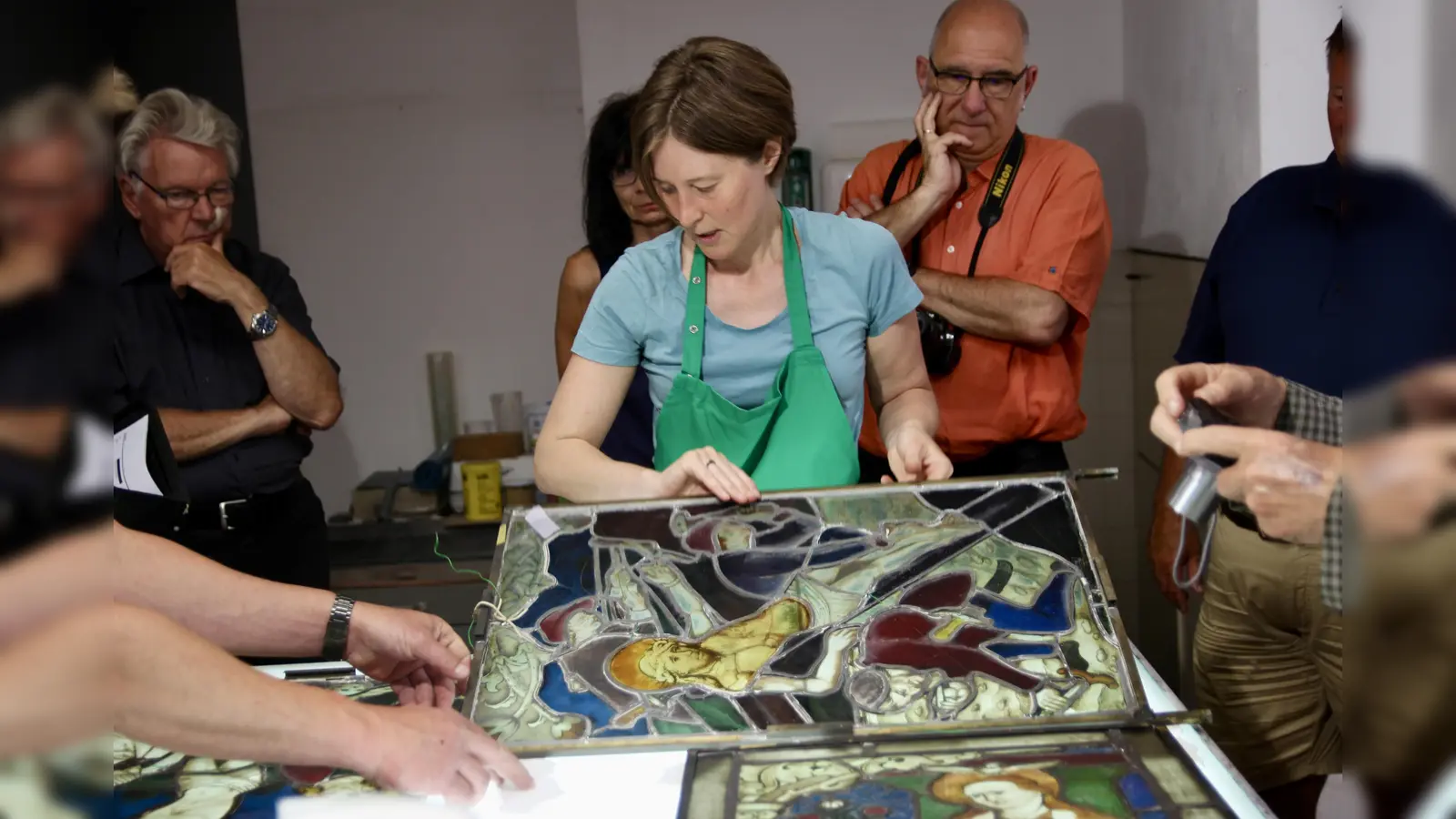 Die Originalfenster der Blutenburger Kapelle von 1497 liegen derzeit in den guten Händen von Hanna Pohle von der Münchner Glasmalerei-Werkstätte. Frieder Vogelsgesang (r.) organisierte einen Werkstattbesuch. (Foto: us)