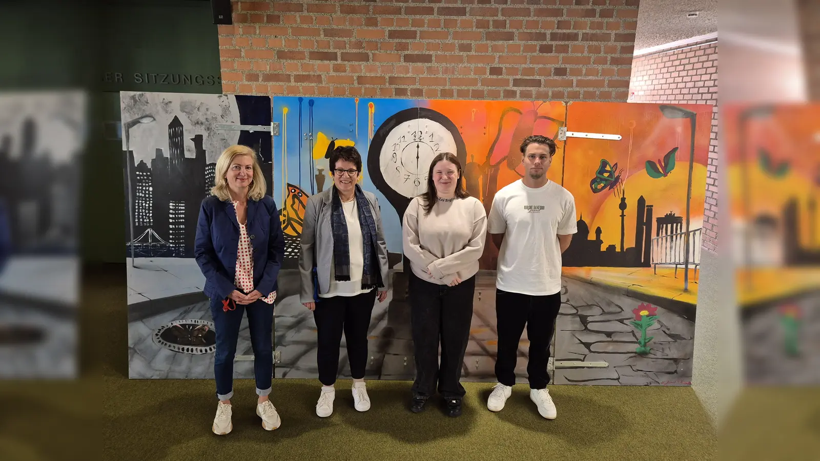 Josefine Müller vom Therapeutischen Zentrum Gauting, Erste Bürgermeisterin Dr. Brigitte Kössinger, Shirley Groß und Benjamin Becker (v. l.)vor dem Triptychon, das in einer „stillen Auktion“ versteigert werden soll. (Foto: Gemeinde Gauting)