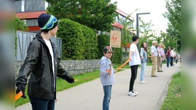 Mithilfe von Abstandsbändern bildeten die Teilnehmer eine Menschenkette der Solidarität. (Foto: Lorenz Hansen)