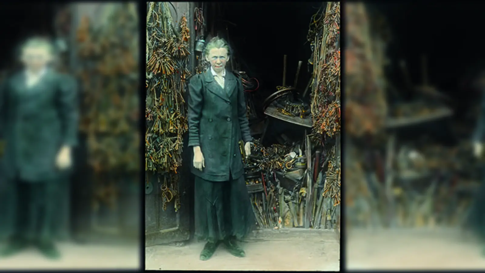 "Schlüsselfräulein" Thekla Foag vor ihrem Laden. Koloriertes Glasdiapositiv, 9 x 12 cm, nur einen Ausschnitt zeigend und damit bewusst den Fokus ausgerichtet auf die Person, das »Original«. (Signatur: DE-1992-FS-NL-KV-2292). (Foto: Stadtarchiv München)