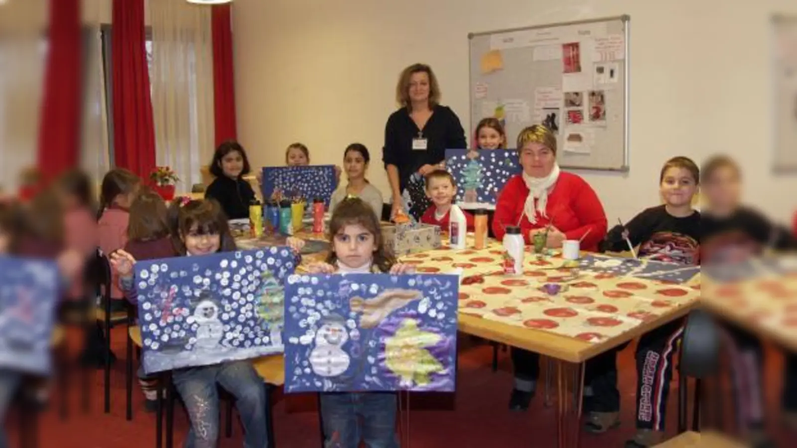 Einmal monatlich bietet Zentrumsmitarbeiterin Elke Hünsche (M.) eine Kinderaktion an: Bei „Spaß im Schnee“ im Januar wurde aus „Materialmangel“ kurzerhand und mit viel Spaß der Schneemann auf Tonpapier gemalt. (Foto: Eva Schraft)