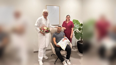 Alea ist das erste Baby im Schwabinger Neubau. Gemeinsam freuen sich (v.l.n.r.): Dr. Olaf Neumann (Chefarzt) Papa Al Ali und Hebamme Anja Gruber. (F.:  München Klinik. )