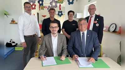 Dennis Behrendt und Stefan Löwl unterzeichnen den Vertrag. Im Hintergrund: Dominik Ulbrich, Michael Schäfer,Larissa Friedl und Bernhard Seidenath. (Foto: BRK Kreisverband Dachau)