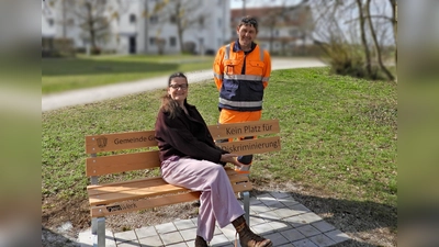 Sabine Ayhan (Inklusionsbeauftragte) und Bauhofmitarbeiter Jürgen Grübler bei einer der neuen Bänke gegen Diskriminierung. (Foto: Gemeinde Gilching)