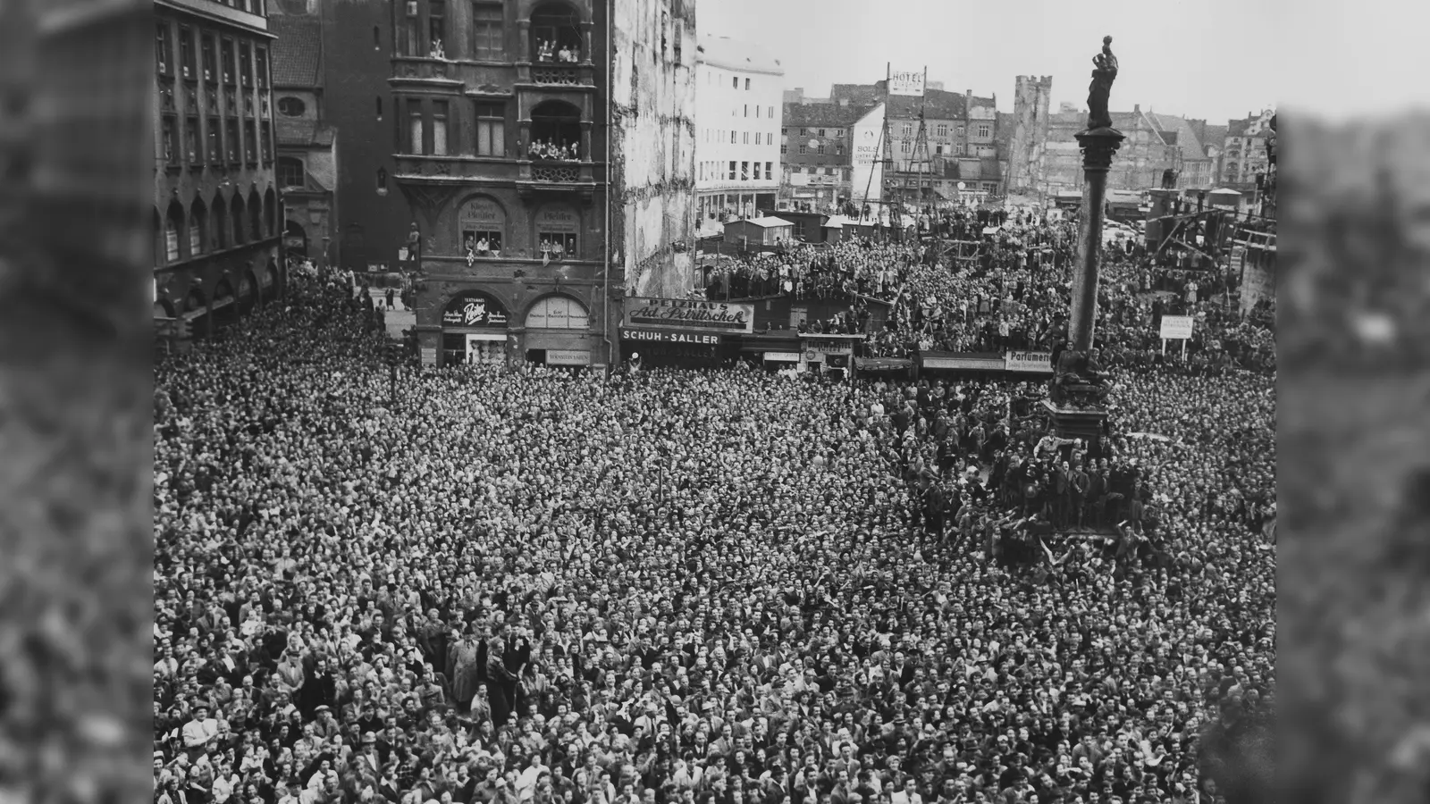 Empfang der deutschen Fußball-Nationalmannschaft, Weltmeister 1954, in München; Blick vom Balkon des Neuen Rathauses auf die Menschenmenge auf dem Marienplatz; Behelfsbauten an der Südseite des Marienplatzes. (Aufnahmedatum: Juli 1954) (Foto: Stadtarchiv München DE-1992-FS-ERG-P-0016)