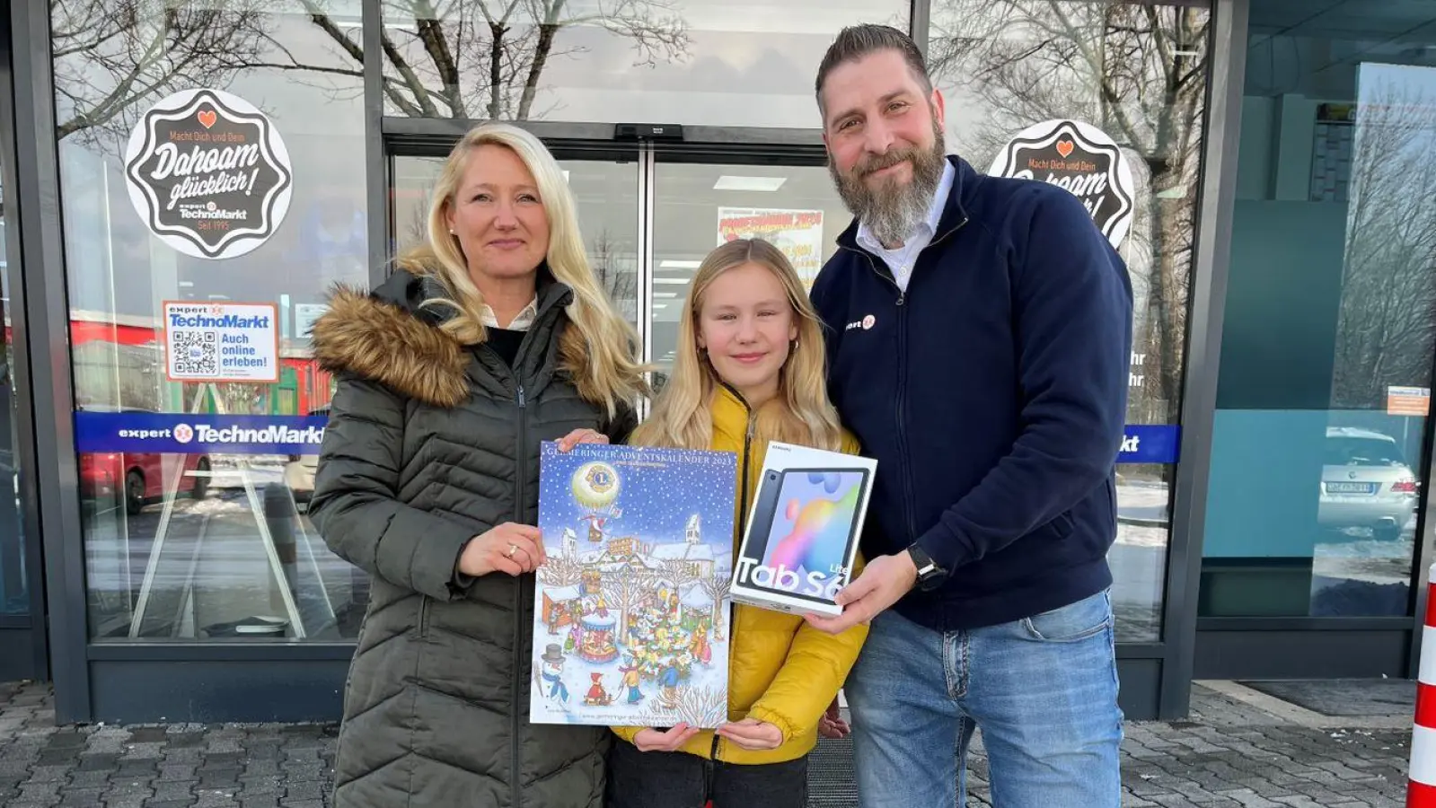 Silke Wolfenstetter (links) und ihre Tochter freuten sich über das Tablet, das ihnen Gerd Hübner vom expert TechnoMarkt Germering überreichte. (Foto: ms)