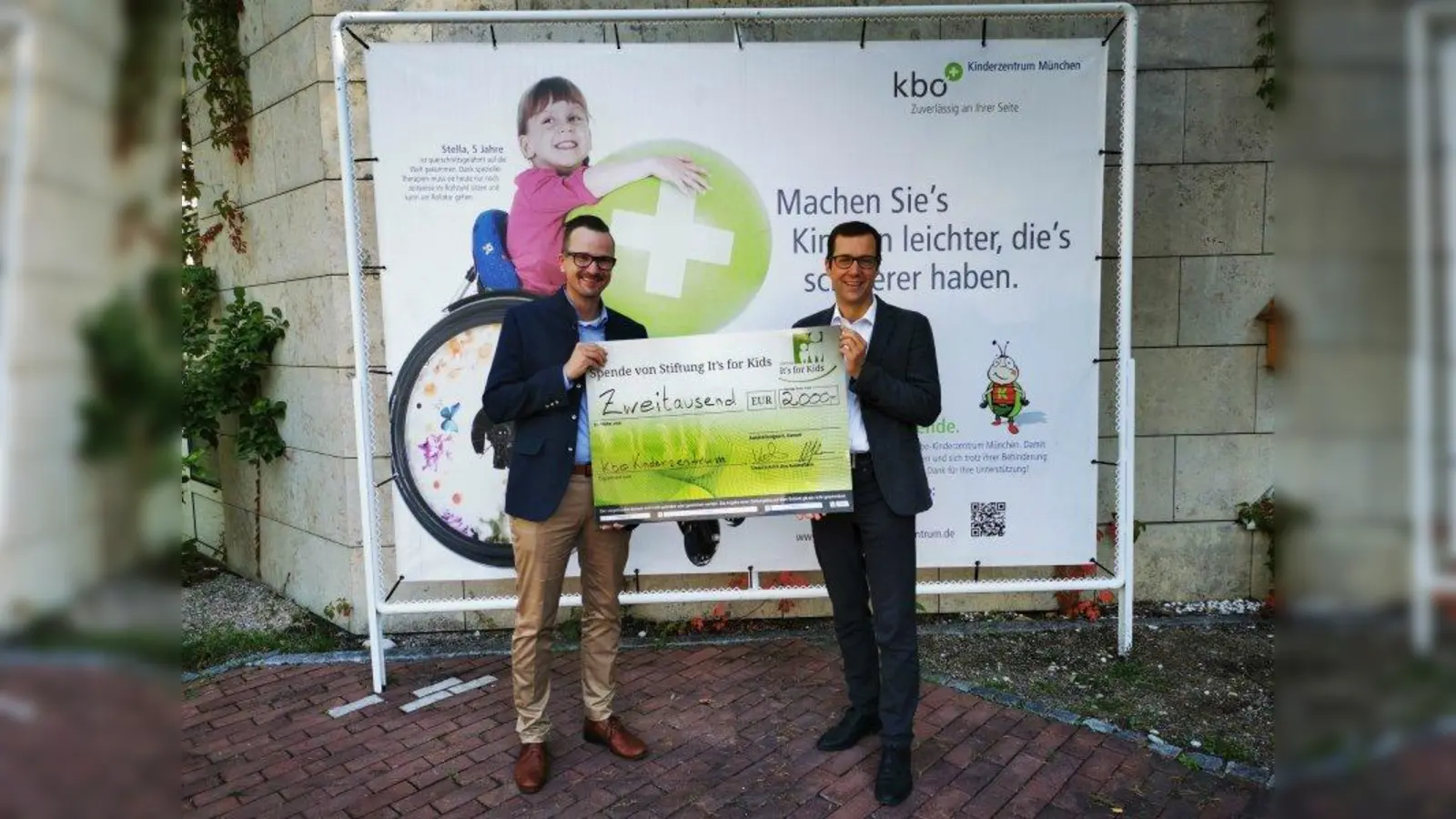 Alte Handys für den Neubau des kbo-Kinderzentrums München: 2.000 Euro hat die Handysammelaktion bereits eingebracht und konnte von Niels Kakies (links) von der Stiftung „It's for Kids” an Prof. Dr. Volker Mall übergeben werden. (Foto: kbo-Kinderzentrum)