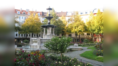 Der Glaspalastbrunnen inmitten von Blumenbeeten auf den Weißenburger Platz. (Foto: gemeinfrei)