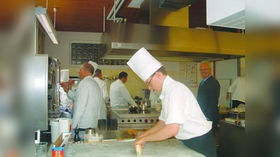 Der Prüfungsstress ist nicht zu unterschätzen: Unter den wachsamen Augen der Prüfer bereiteten die Küchenmeister-Anwärter ein Fünf-Gänge-Menü zu. Rechts: Kermess-Leiter Hans Passian, der sich sehr freute, als schließlich bekanntgegeben wurde, dass alle Prüflinge bestanden haben. (Foto: bb)
