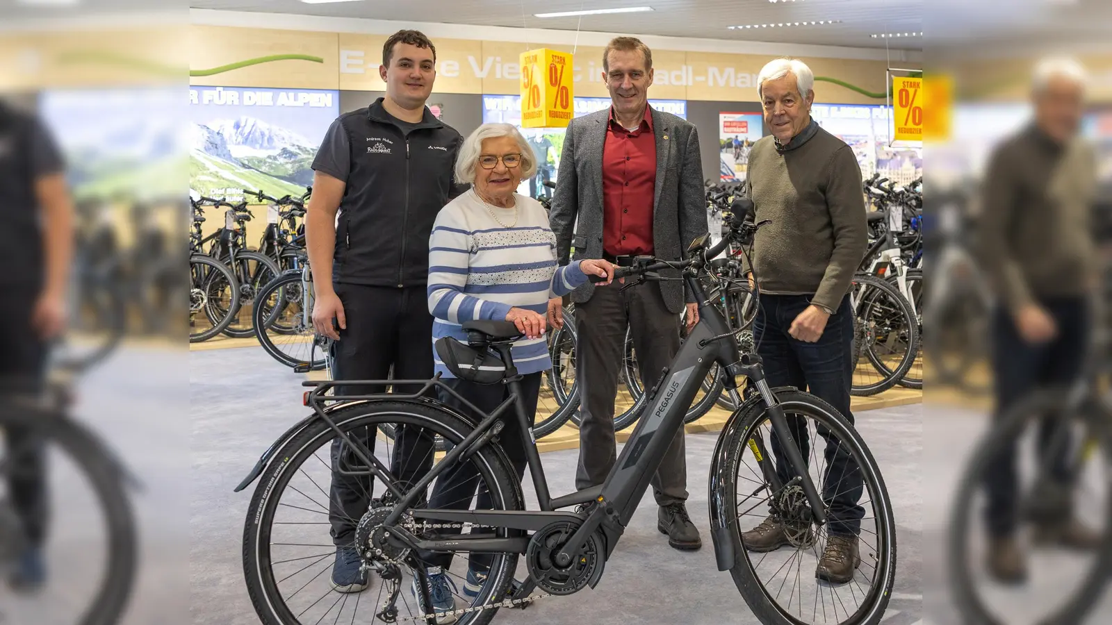 Hannelore Biffar bei der Übergabe des E-Bikes mit Andreas Huber (l. vom Radl Markt) und Lions Präsident Michael Sigmund (2.v.r.) sowie Adventskalender-Initiator Fred Burgstaller. (Foto: Walter Weiss)