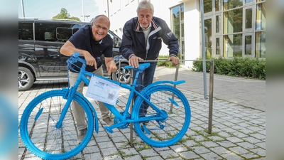 Für Kinderrechte: 1. Bürgermeister Christian Schiller (l.) und 3. Bürgermeister Wolfgang Schneider an dem knallblauen Rad vor dem Rathaus Herrsching. (Foto: Gemeinde)