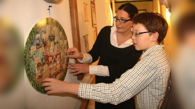 Das Altenheim Planegg stellt eine große Sammlung von historischen und modernern Adventskalendern aus. „Wir freuen uns auf viele Besucher. Jung und Alt sind gerne gesehen“, so Heimleiter Ulrich Spies. Im Bild Karola Albrecht mit Sohn Felix. (Foto: US)