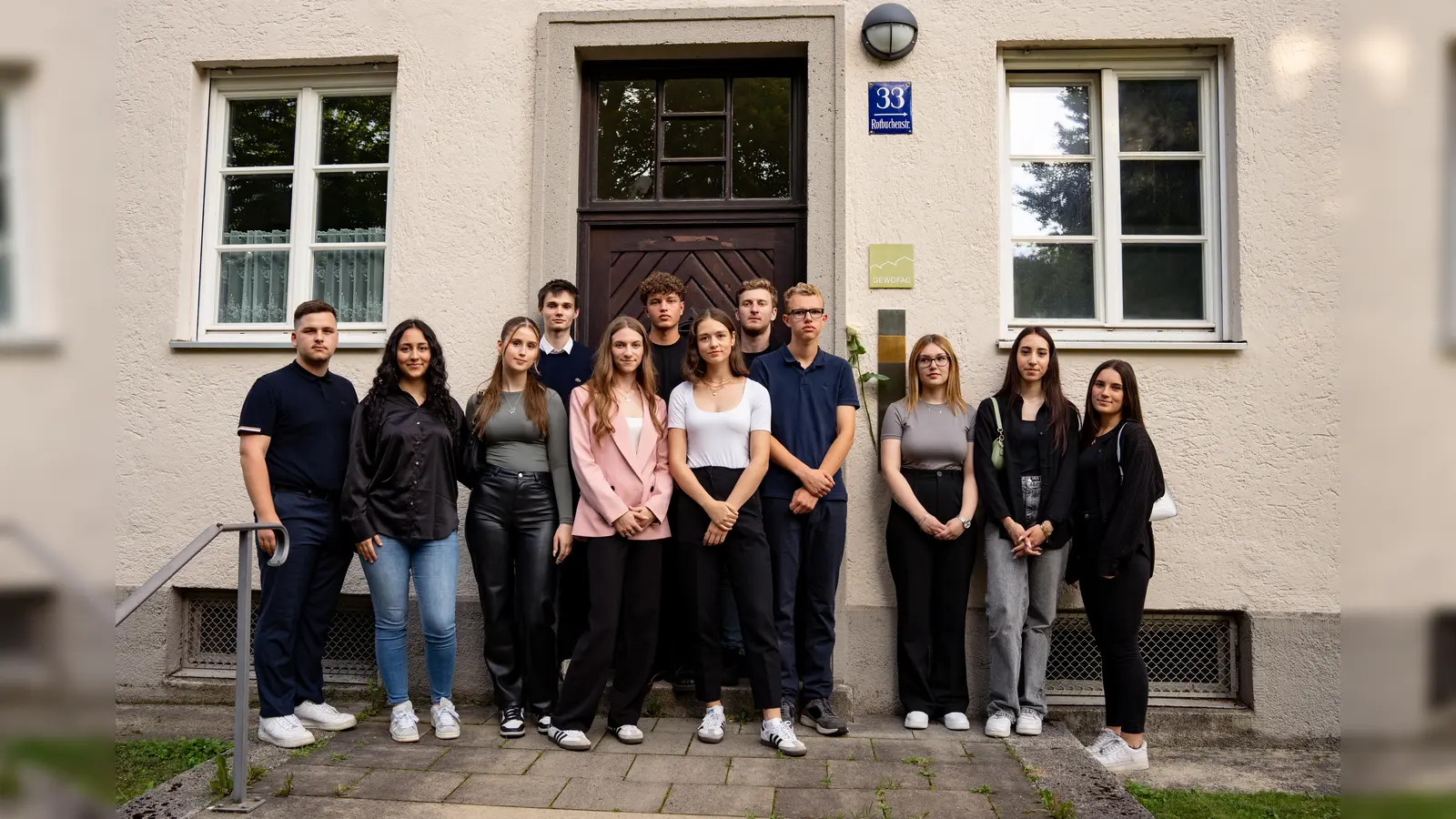 Auszubildende der Münchner Wohnen vor dem Erinnerungszeichen für Alois Koller, das in der Rotbuchenstraße 33 gesetzt worden ist. (Foto: Münchner Wohnen, Jonas Nefzger)