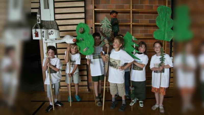 Da lief gleich ganz Maria Eich beim Festumzug mit: Die Planegger Schule der Phantasie bebilderte die Ortsgeschichte aus Pappmachee, wie hier die Kirche Maria Eich, Waldtiere, Bäume und ein Jäger. Die T-Shirts der Kinder waren mit historischen Postkarten bedruckt. (Foto: US)