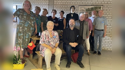 Die Teilnehmer des Vereins „Langwied Lochhausen Historisch” mit Vorsitzender Barbara Kuhn (links) und Stellvertreter Detlef Kohler (sitzend) mit einer Lehrer-Puppe (hintere Reihe) in dem nachgestellten Klassenzimmer. (Foto: pst)