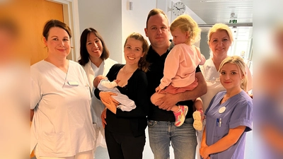 Oberärztin Anna-Lisa Spranger, Chefärztin Dr. Helen Budiman, Mama Corinna Jehl mit Baby Martin, Papa Martin Jehl mit Sophia, Kinderkrankenschwester Violeta Teneva und Hebamme Selina Spötzl (von links) beim Fototermin für Jubiläumsbaby Martin.<br><br> (Foto: Klinik Ebersberg)
