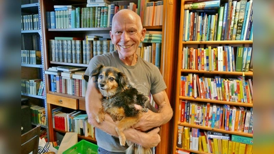 Umgeben von Büchern: Anton Größ mit seiner Coco. (Foto: Tierschutzverein München e.V.)