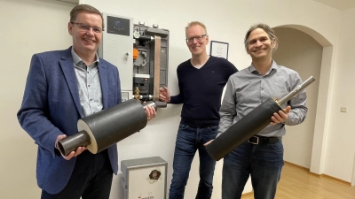 Bürgermeister Manfred Walter (li.) und Projektleiter Jan Haas (re.) präsentieren Teilstücke von Fernwärme-Rohren. Geschäftsführer der Gemeindewerke Klaus Drexler demonstriert die Technik. (Foto: pst)